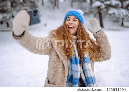 Happy female traveler with phone enjoying winter day outdoors. Christmas time. 133651094