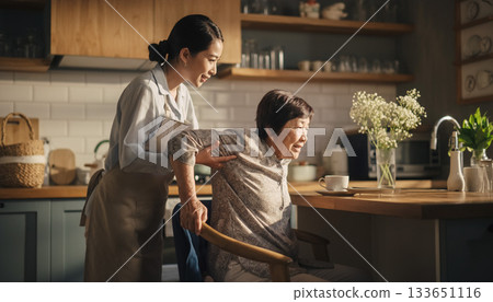 A warm scene of a caregiver helping an elderly woman in her kitchen A warm scene of a caregiver helping an elderly woman in her kitchen 133651116