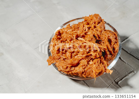glass bowl packed with moist shredded pulled pork 133651154