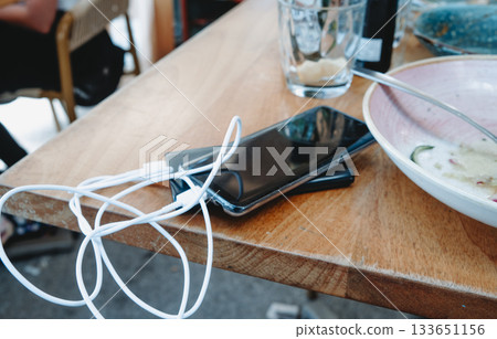 a phone charging on a restaurant table 133651156