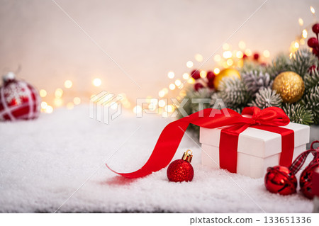 Christmas Gift and Ornaments on Snow with Tree Branches 133651336