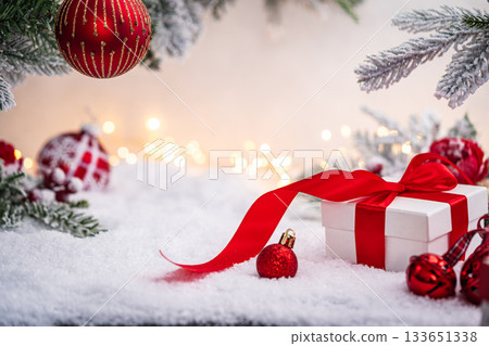 Christmas Gift and Ornaments on Snow with Tree Branches Christmas Gift and Ornaments on Snow with Tree Branches 133651338