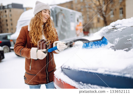 Cleaning snow from a car. Transport concept, seasonality Winter glass cleaning. Cleaning snow from a car. Transport concept, seasonality Winter glass cleaning. 133652111