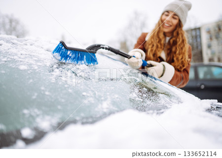 Cleaning snow from a car. Transport concept, seasonality Winter glass cleaning. 133652114