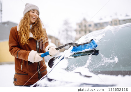 Cleaning snow from a car. Transport concept, seasonality Winter glass cleaning. Cleaning snow from a car. Transport concept, seasonality Winter glass cleaning. 133652118