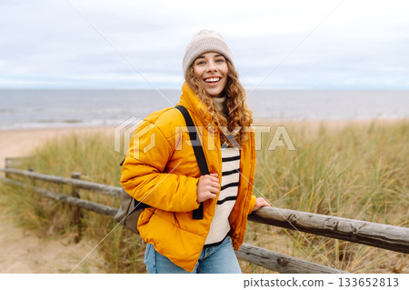 Attractive woman on a windy cold beach. Travel, nature concept. Attractive woman on a windy cold beach. Travel, nature concept. 133652813