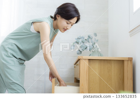 A woman putting clothes away in a dresser A woman putting clothes away in a dresser 133652835