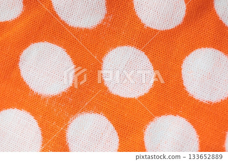 Macro texture of retro orange fabric with white polka dots. Stylish background for vintage, textile, design, fashion, home decor, and creative projects 133652889