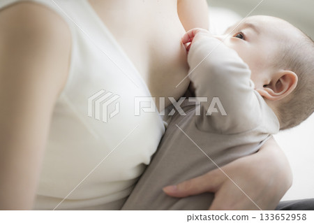 Mother giving milk to her baby 133652958