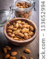 Almond kernel nuts in bowl on wooden table. 133652994