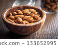 Almond kernel nuts in bowl on wooden table. 133652995
