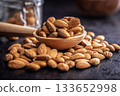 Almond kernel nuts on wooden spoon on black table. 133652998