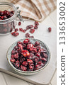 Tasty dried cranberries in bowl on white table. 133653002