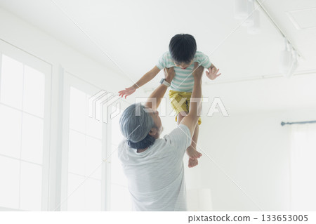 A cheerful grandfather holding his grandson A cheerful grandfather holding his grandson 133653005