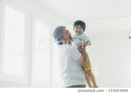A cheerful grandfather holding his grandson 133653008