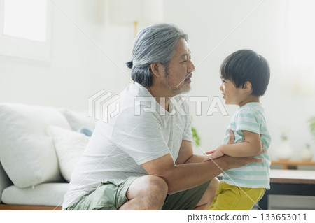 A cheerful grandfather holding his grandson A cheerful grandfather holding his grandson 133653011