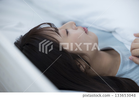 A woman lying in bed 133653048
