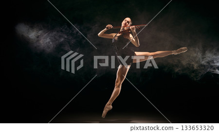 Jumping ballerina playing violin in smoky stage environment Jumping ballerina playing violin in smoky stage environment 133653320