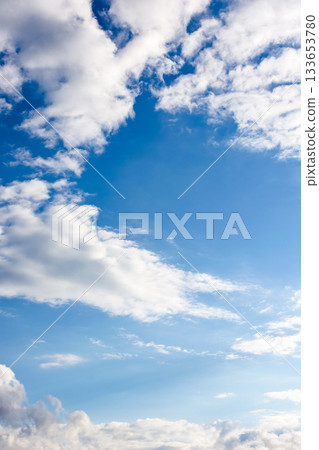 clear blue sky with white fluffy clouds. vertical nature background. soft cumulus cloudscape wallpaper on a bright day. fresh air due to reduced emission in summer atmosphere clear blue sky with white fluffy clouds. vertical nature background. soft cumulus cloudscape wallpaper on a bright day. fresh air due to reduced emission in summer atmosphere 133653780