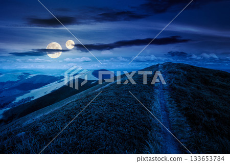 path to the mountain top at night. beautiful summer scenery with dynamic clouds on a dark sky in full moon light. scenic landscape with rolling hills. background for fake news or conspiracy concepts path to the mountain top at night. beautiful summer scenery with dynamic clouds on a dark sky in full moon light. scenic landscape with rolling hills. background for fake news or conspiracy concepts 133653784