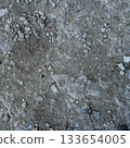 Close-up of a gray-black lava texture on the ground. Porous, cracked, and stony, perfect as a stock texture or photo background. Impression of molten rock. 133654005