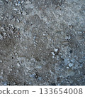 Close-up of a gray-black lava texture on the ground. Porous, cracked, and stony, perfect as a stock texture or photo background. Impression of molten rock. 133654008