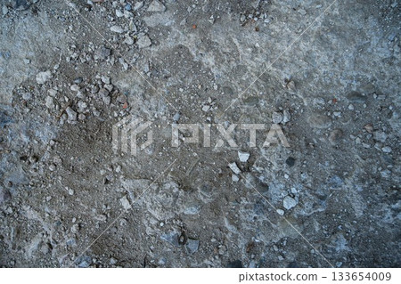 Close-up of a gray-black lava texture on the ground. Porous, cracked, and stony, perfect as a stock texture or photo background. Impression of molten rock. 133654009