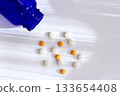 Healthcare image of pills and blue bottles spread out on white background 133654408