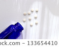 Healthcare image of pills and blue bottles spread out on white background 133654410