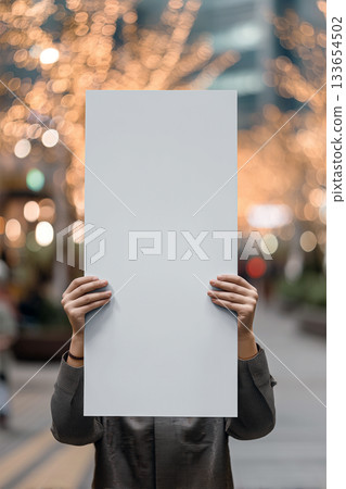 Realistic banner mockup in hands with soft bokeh and a vivid outdoor atmosphere 133654502