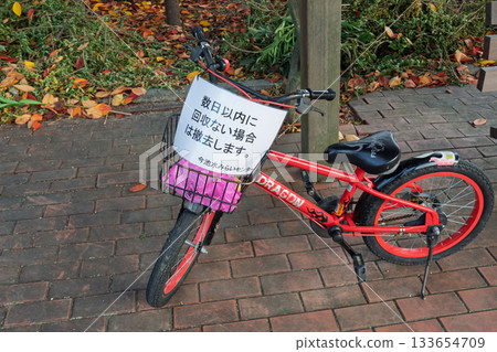 A bicycle with a sign saying, "If not collected within a few days, it will be removed." A bicycle with a sign saying, "If not collected within a few days, it will be removed." 133654709