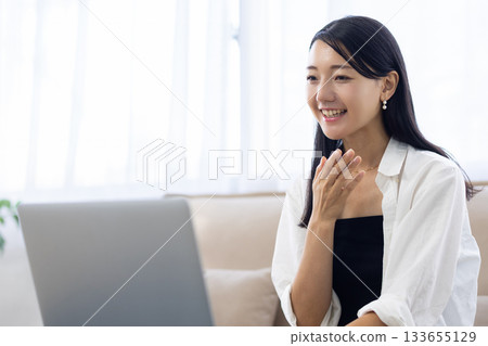 Young woman making a video call on a laptop in the living room at home 133655129