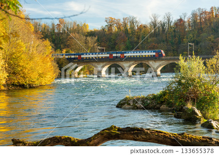 秋天，瑞士沙夫豪森州諾伊豪森，一列火車穿過萊茵瀑布上方的勞芬橋 133655378