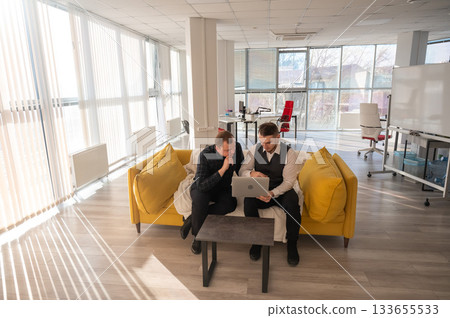 Two Caucasian men looking at a laptop and discussing work.  133655533