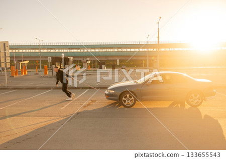 Caucasian man pulling a car with a rope. Caucasian man pulling a car with a rope. 133655543