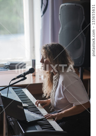 Caucasian woman singing into microphone and playing synthesizer. Online lesson on laptop. Caucasian woman singing into microphone and playing synthesizer. Online lesson on laptop. 133655631
