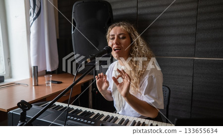 Caucasian woman singing into microphone in music studio. Caucasian woman singing into microphone in music studio. 133655634