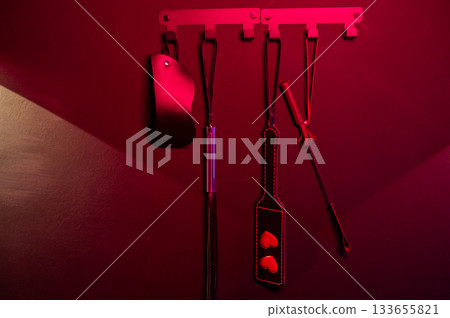 A set of BDSM accessories hangs on the wall. A set of BDSM accessories hangs on the wall. 133655821