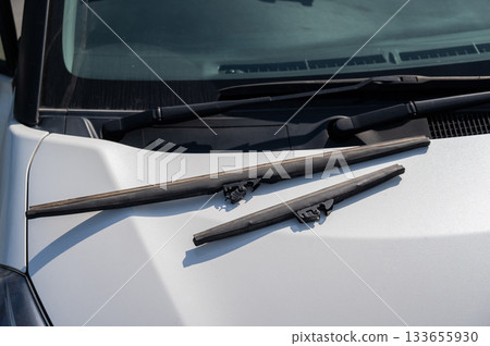 Windscreen wipers lying on the hood. Seasonal replacement. Windscreen wipers lying on the hood. Seasonal replacement. 133655930