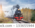 Steam retro train moves in the autumn forest at sunrise. 133655944