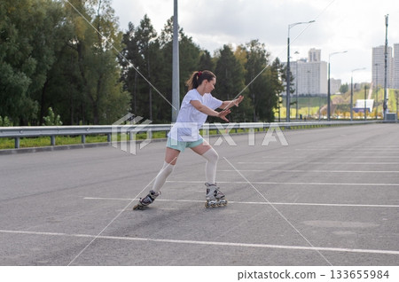 Caucasian woman in shorts roller skating.  133655984