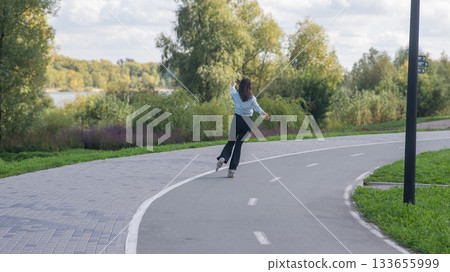 Caucasian woman roller skating in park.  133655999