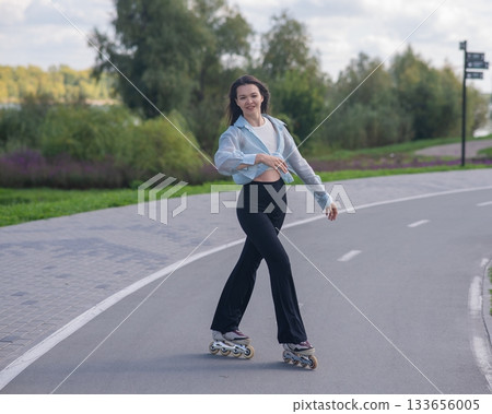 Caucasian woman roller skating in park.  133656005
