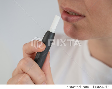 Woman smoking tobacco heating system. Electronic cigarette. Woman smoking tobacco heating system. Electronic cigarette. 133656018
