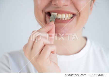 Woman Chewing Nicotine Snus Product. Woman Chewing Nicotine Snus Product. 133656019