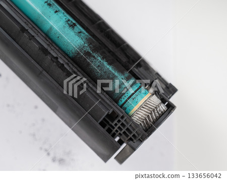 Broken laser printer cartridge on white background.  133656042