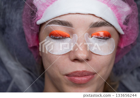 Caucasian woman undergoing eyelash lamination procedure. top view. Caucasian woman undergoing eyelash lamination procedure. top view. 133656244