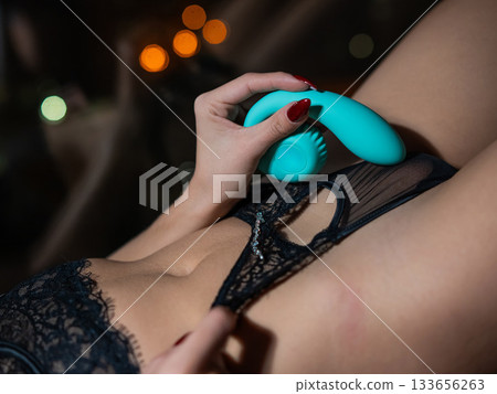 Woman uses blue curved vibrator.  133656263