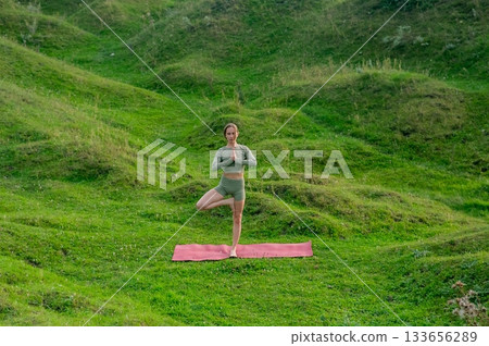 Caucasian woman doing yoga outdoors. Tree pose. Caucasian woman doing yoga outdoors. Tree pose. 133656289