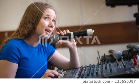 Young woman mixing live sound. Girl recording a song in the studio.  133656397